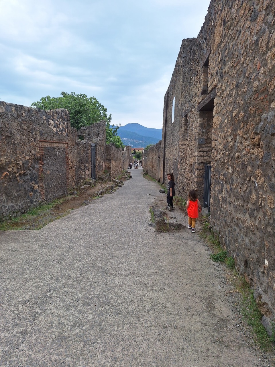 A quiet street in the hilltop town of Caiazzo, warm stone houses on either side and a glimpse of the countryside at the end of the lane