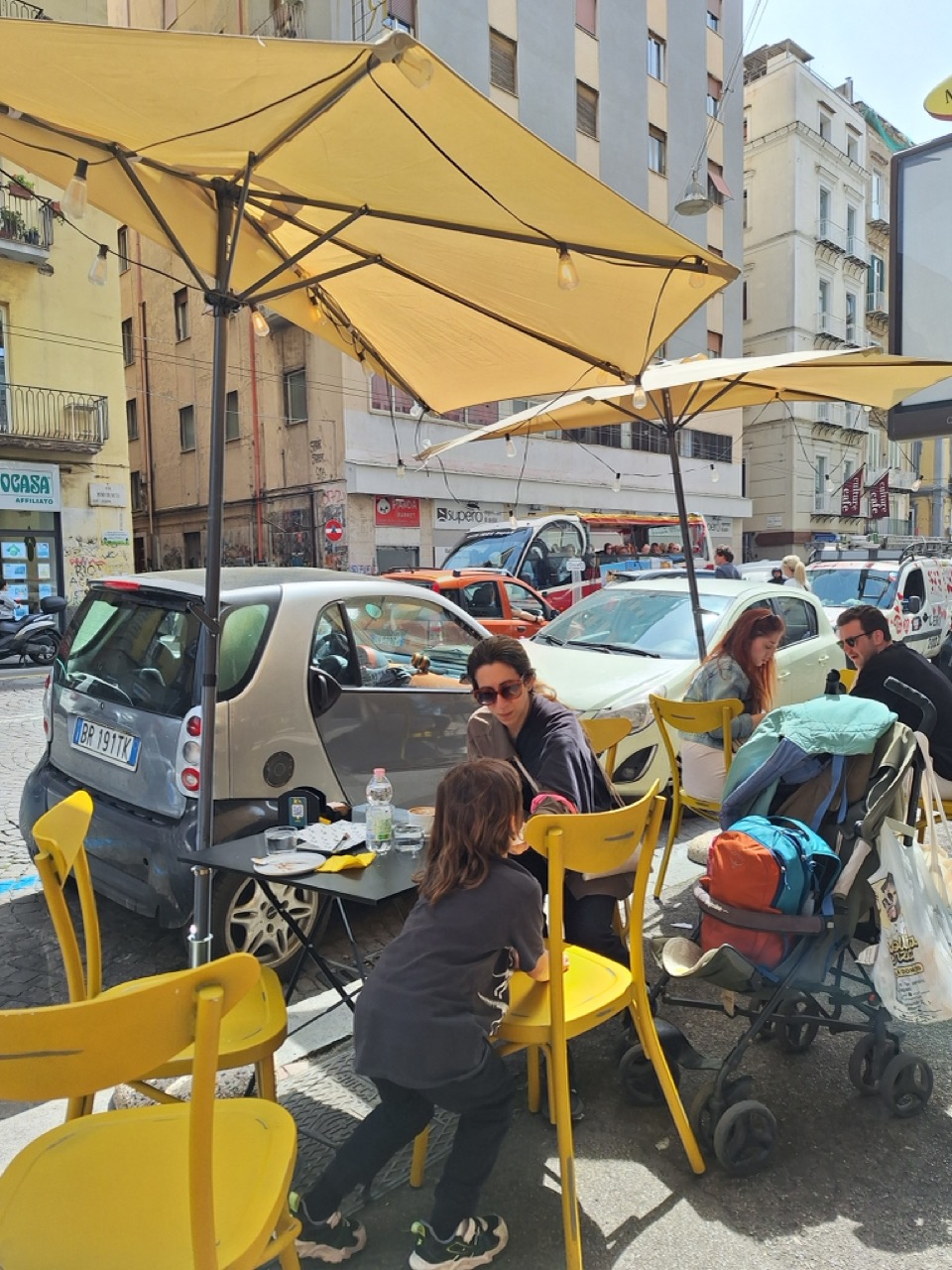 Street café with yellow chairs in Naples