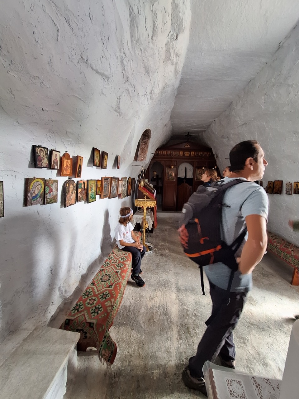 Inside a chapel carved into the rock, walls covered with icons