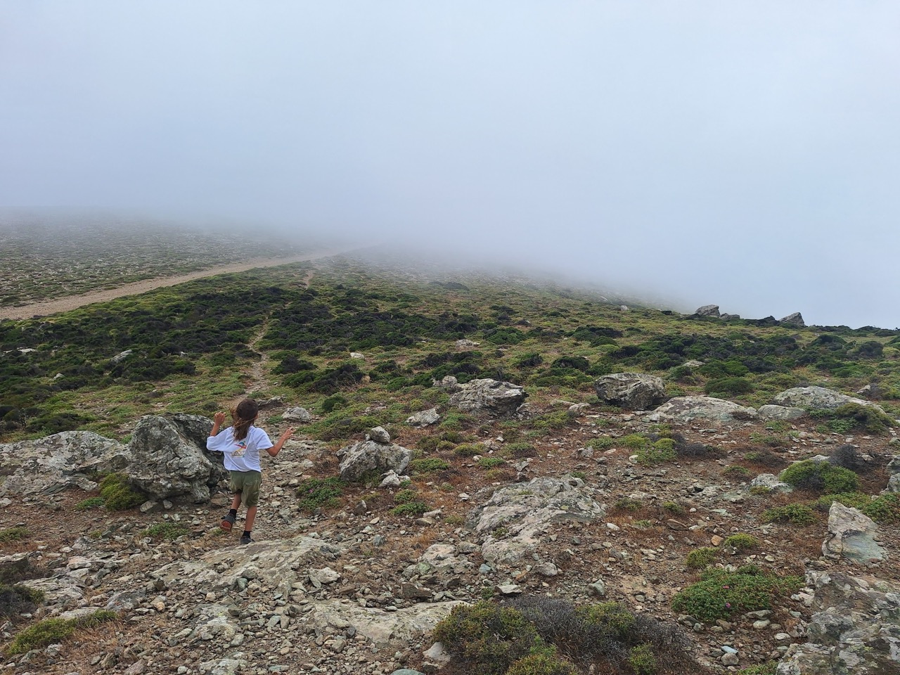 A young hiker walking between weathered granite boulders