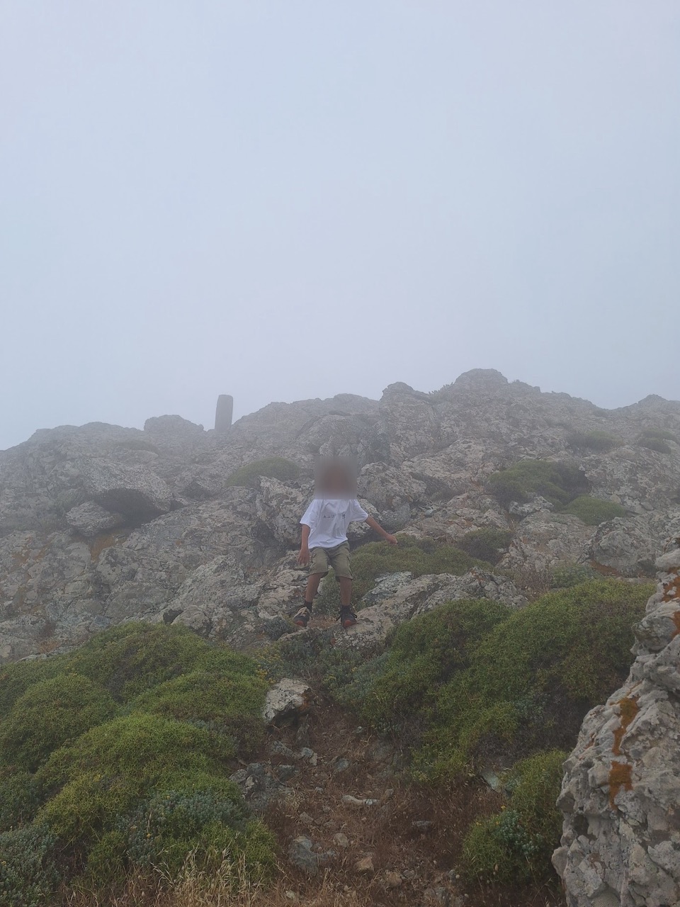 A father and son taking a rest against a rock on the ascent