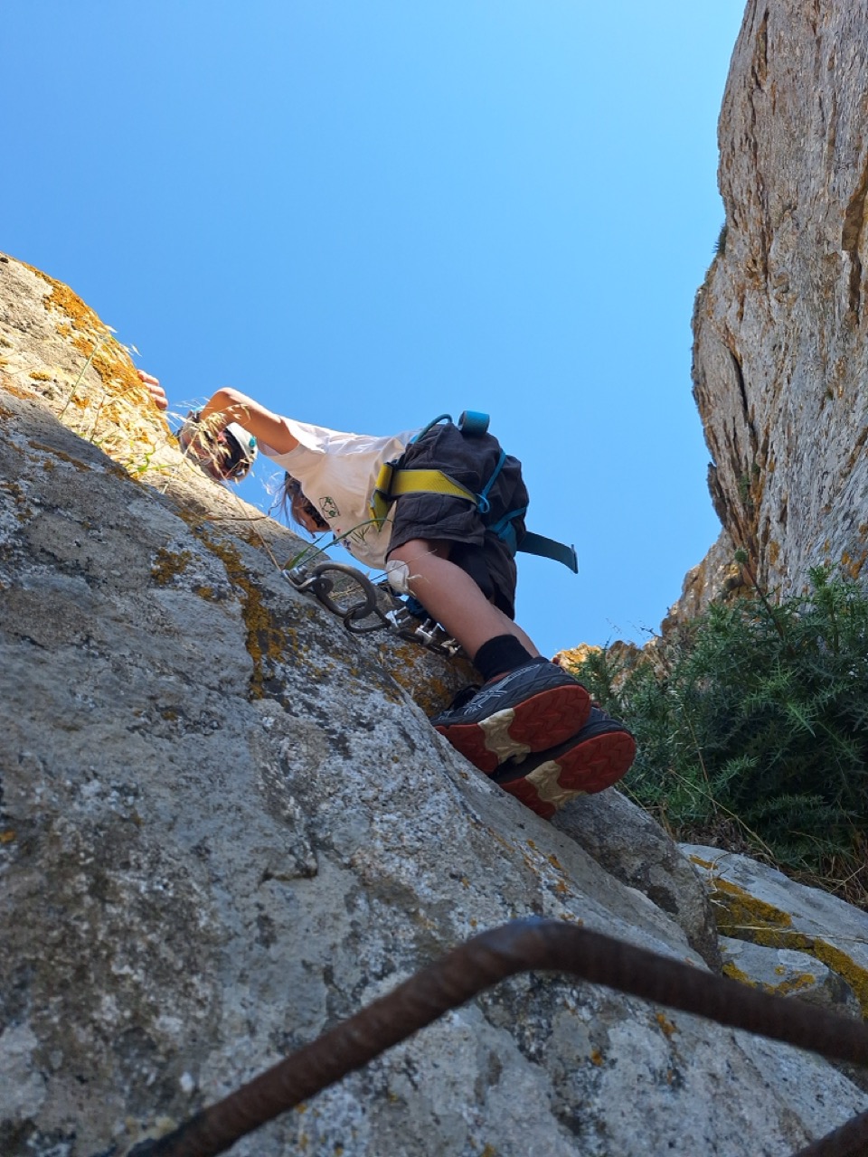 George climbing up the rock face, seen from below